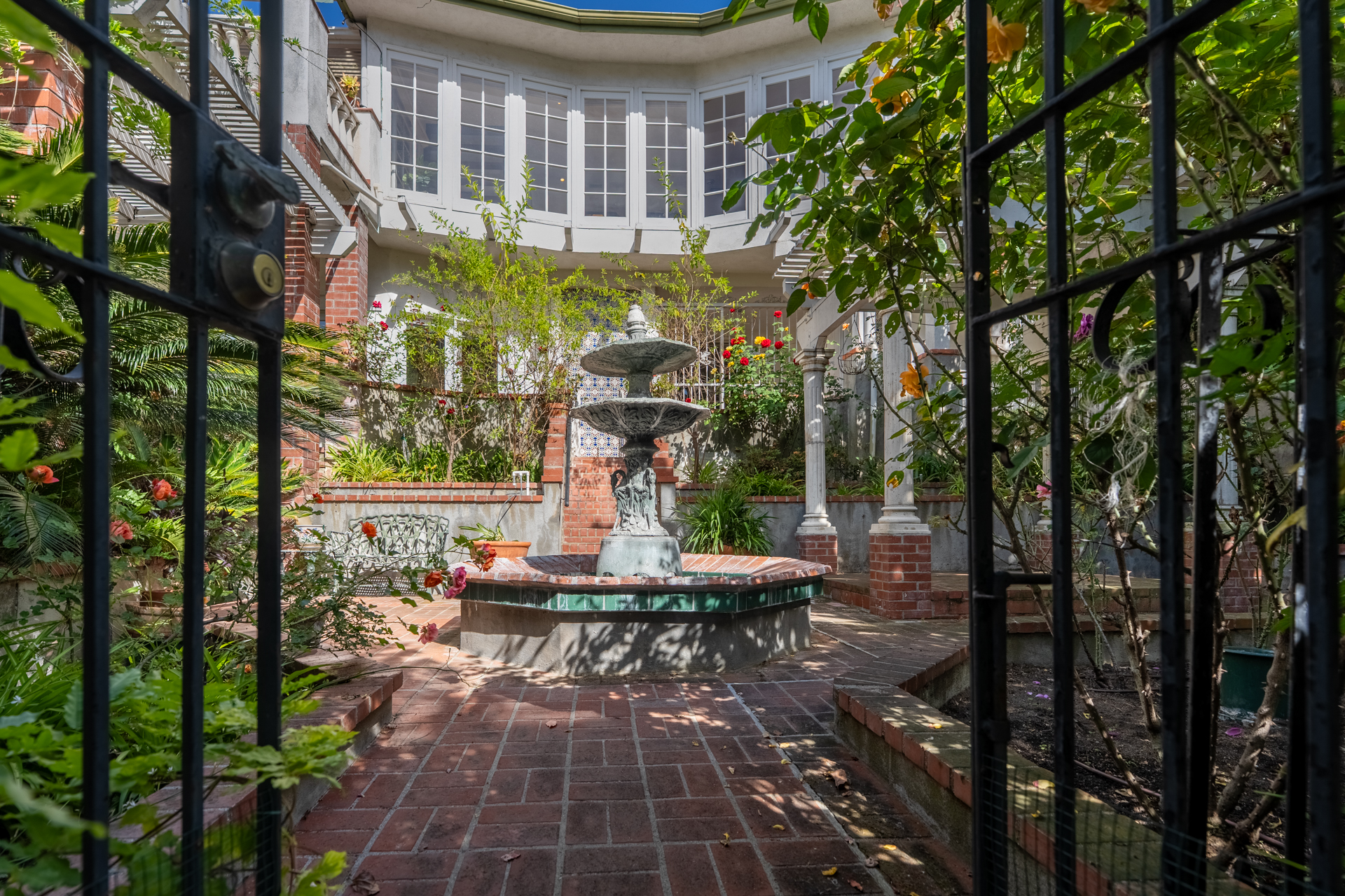 Courtyard fountain, framed by iron and banana leaves